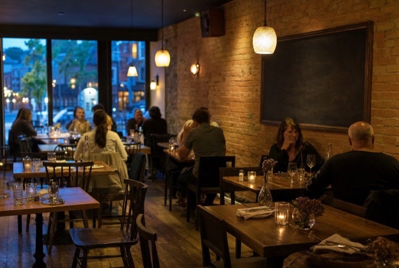A warmly lit restaurant dining room with an exposed brick wall and candlelit wooden tables, the kind of local eatery SEO Westwood works with